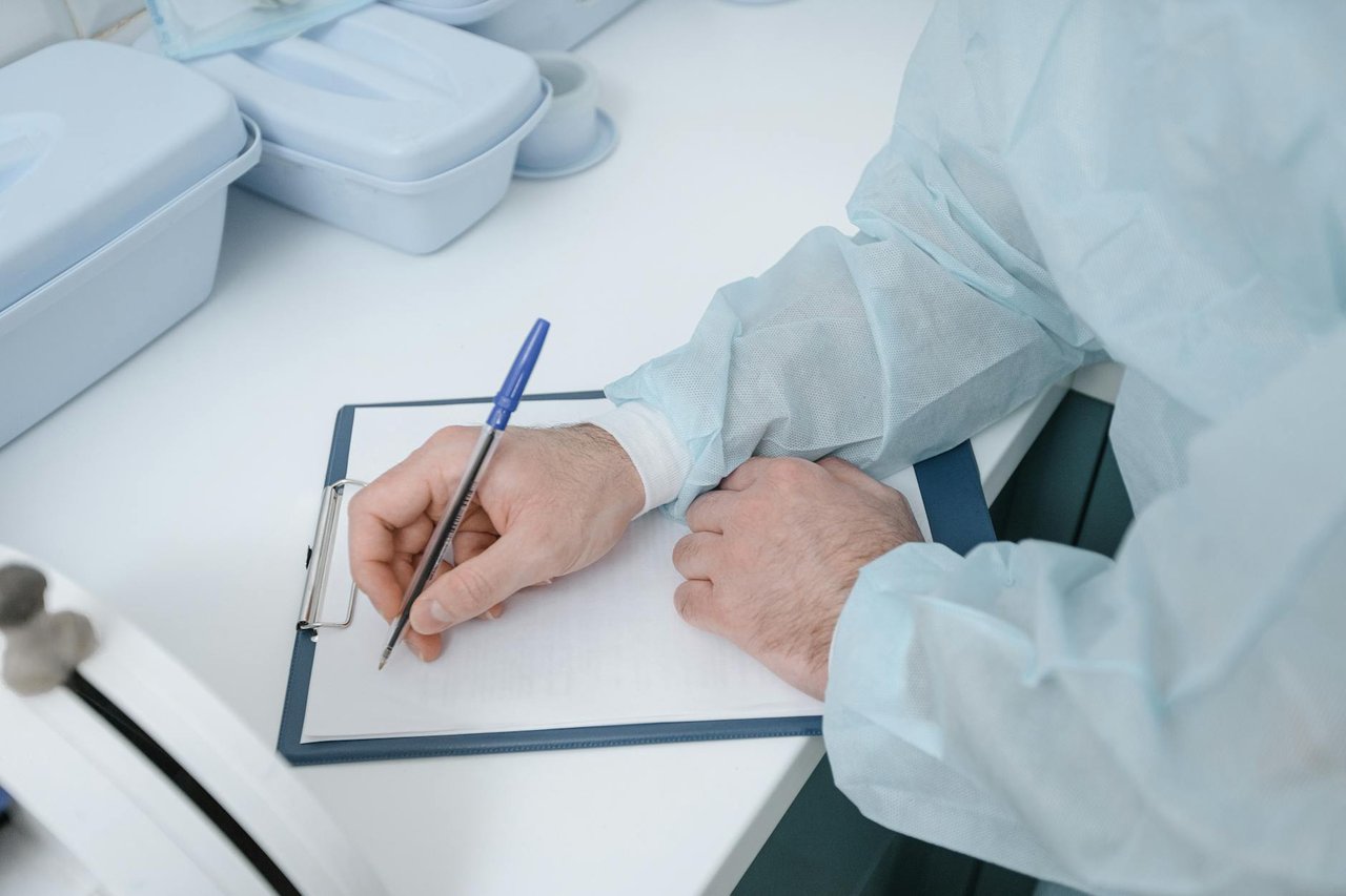 Medical professional reviewing compliance documents at a desk